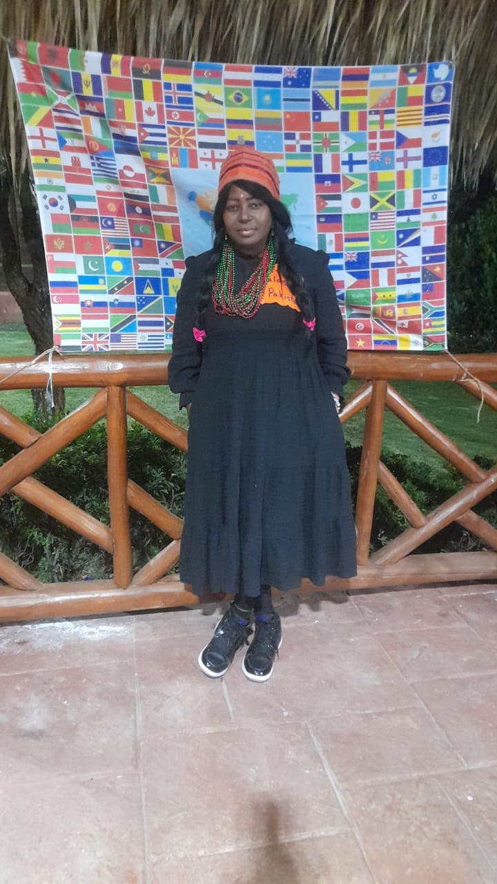 Tía Wendy frente a banderas del mundo